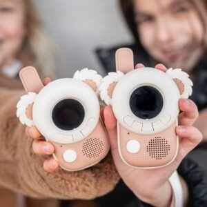 Two pink bear-themed toy cameras with round lens screens and fluffy ears, held by smiling kids behind them back-to-back in a close-up.