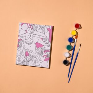 Open coloring book with a detailed line drawing of birds and flowers on a peach background, with paints and brushes to the right.